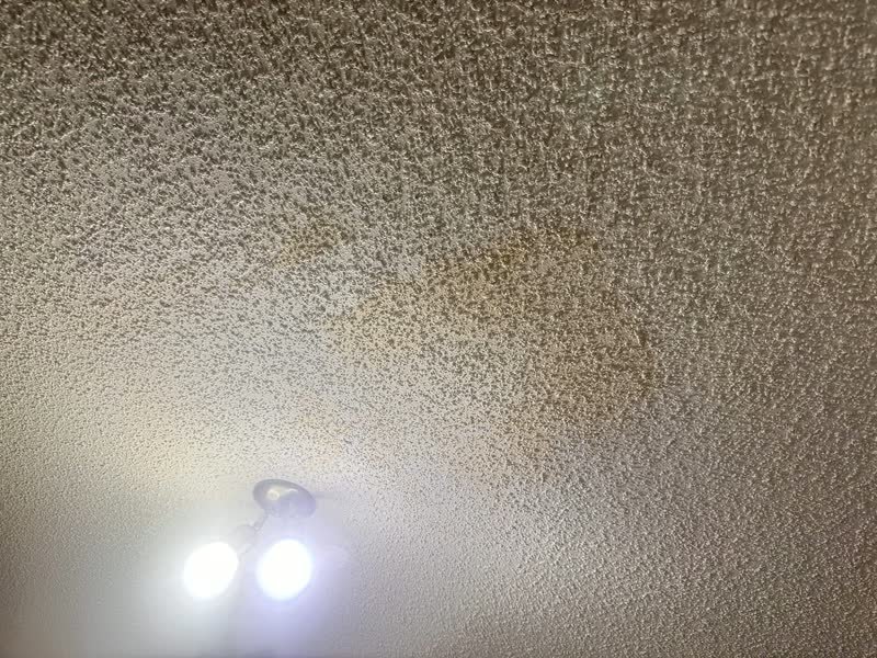 Popcorn ceiling with a brown water stain