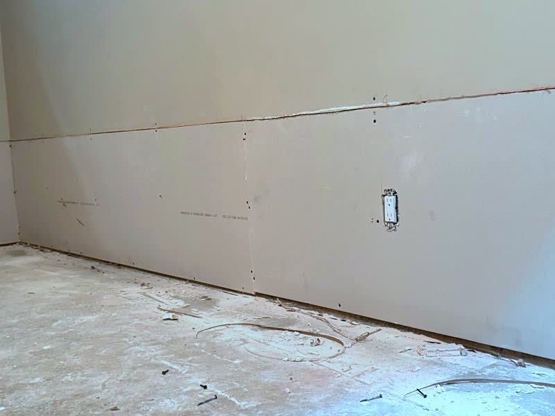 New drywall sheets installed along a basement wall by Titanrise