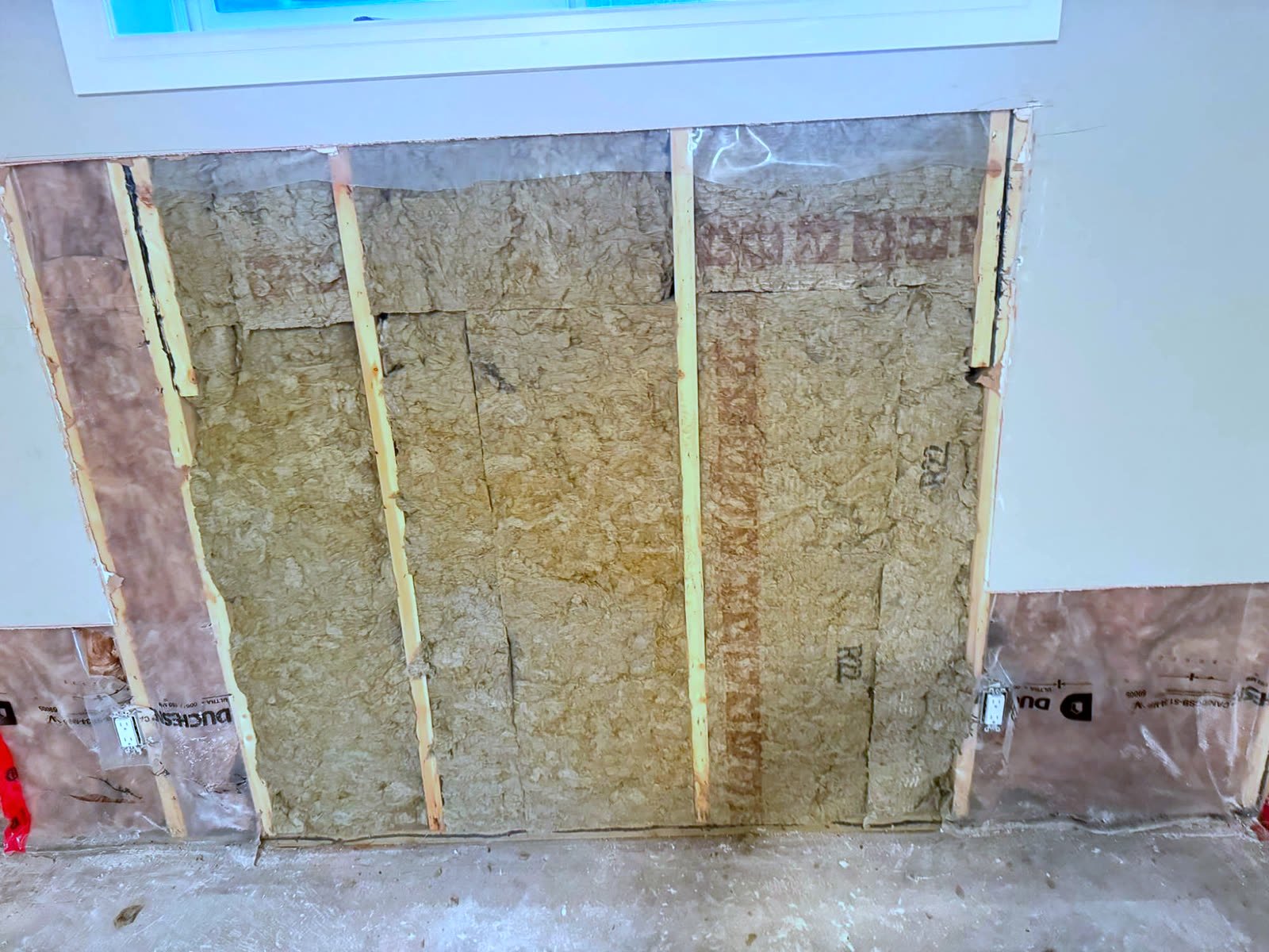Before: wall opened with water-damaged insulation